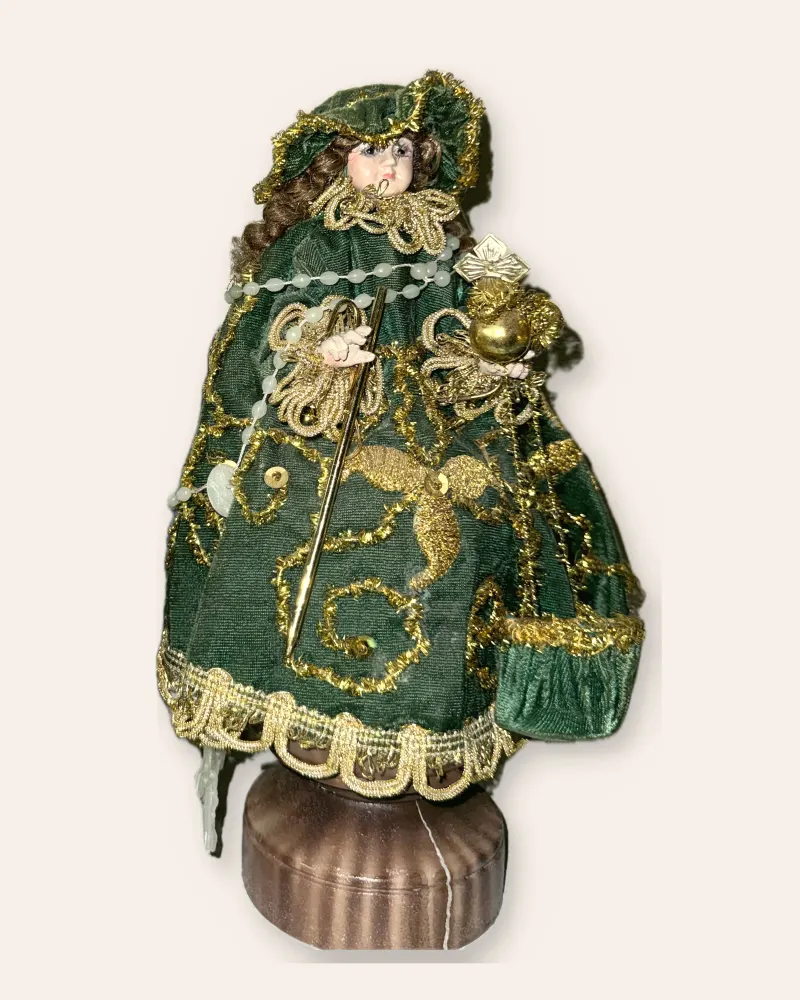 A Santo Nino statue in a red and gold robe, the figure the app shows on Joyful Mystery days